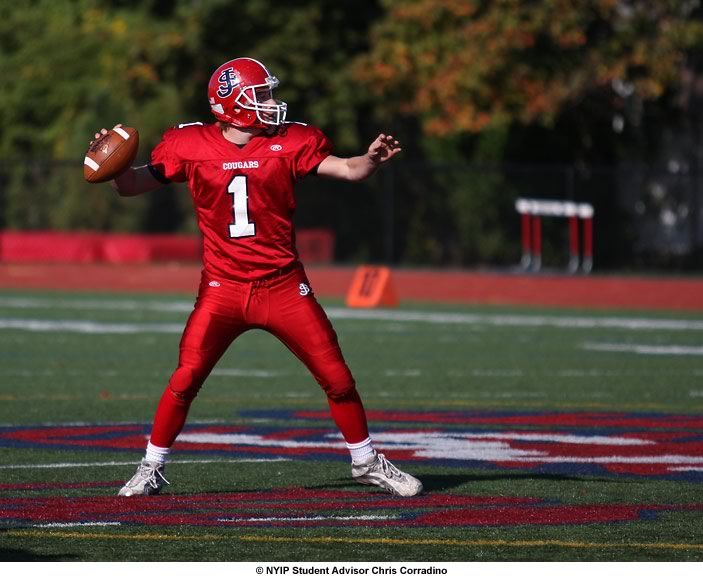 A wide aperture of f2.8 was used to focus attention on the Quarterback while blurring
the background. The bright red uniform contrasts nicely with the fall foliage in the background and the green
of the field.